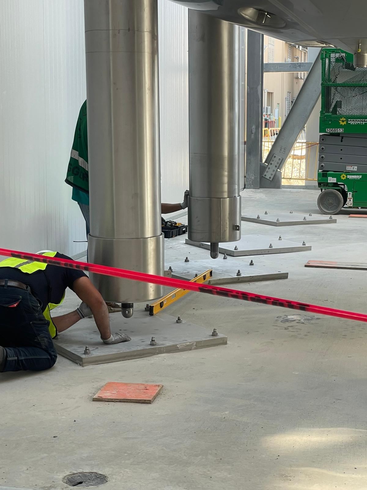 Technician leveling and anchoring a tank leg