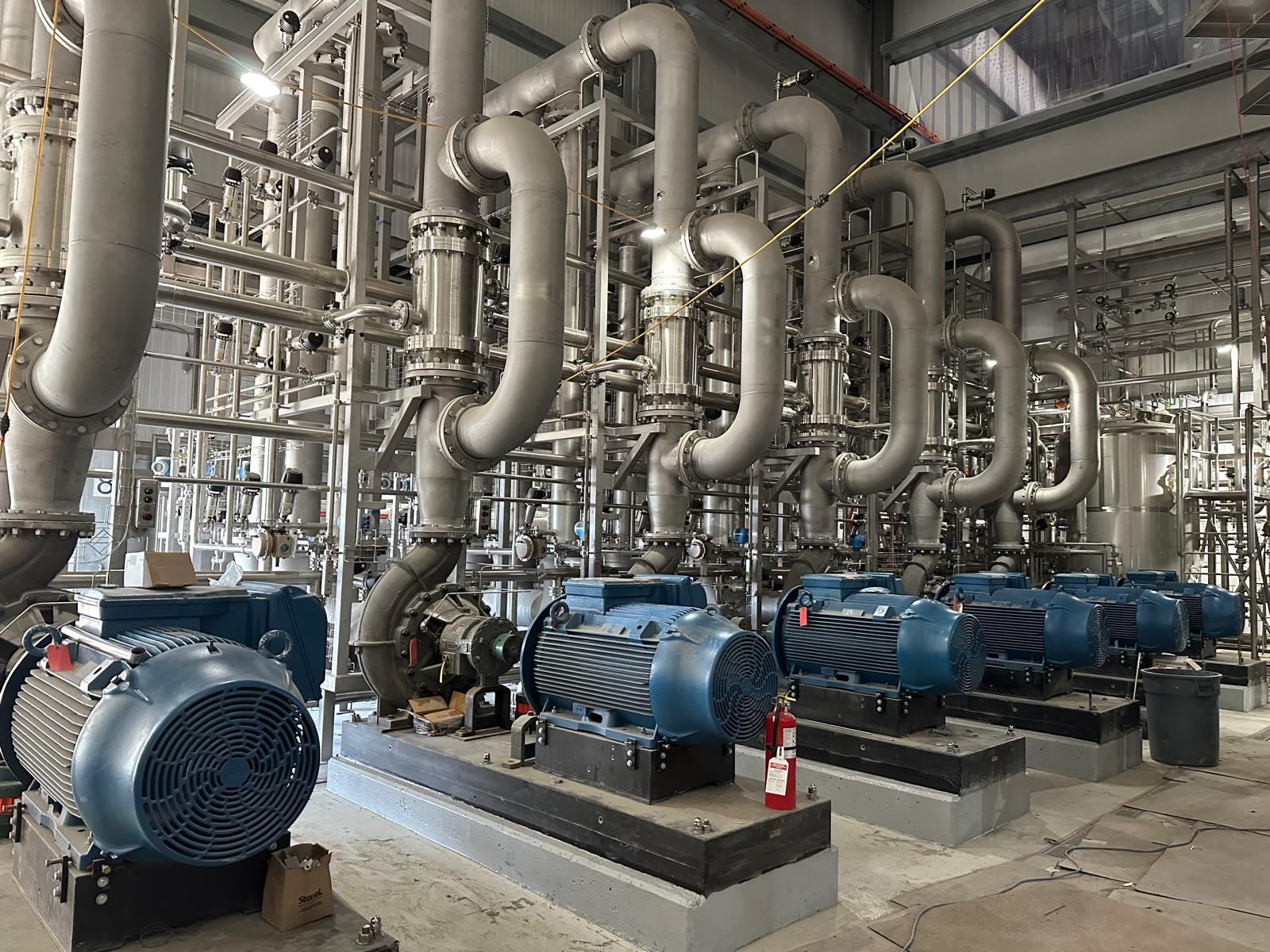 Row of process pumps connected to stainless piping