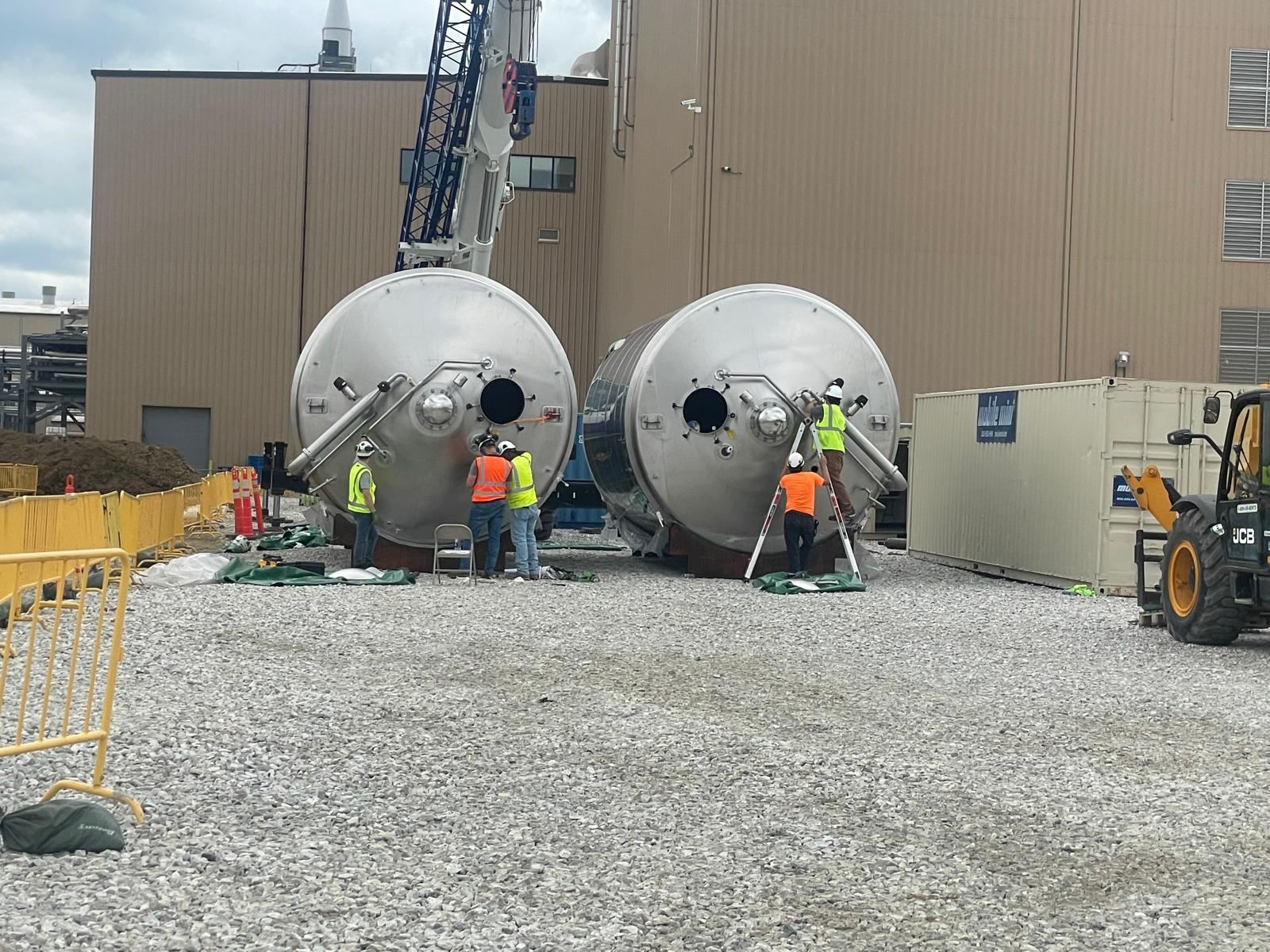 Two stainless tanks staged outside the plant